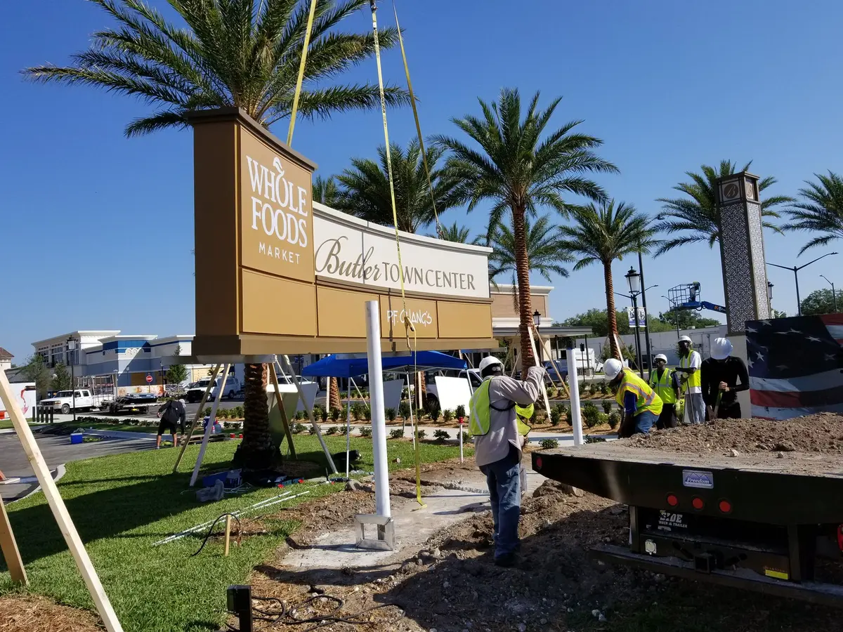 Pylon sign lifted by crane with the installation crew at Butler Town Center