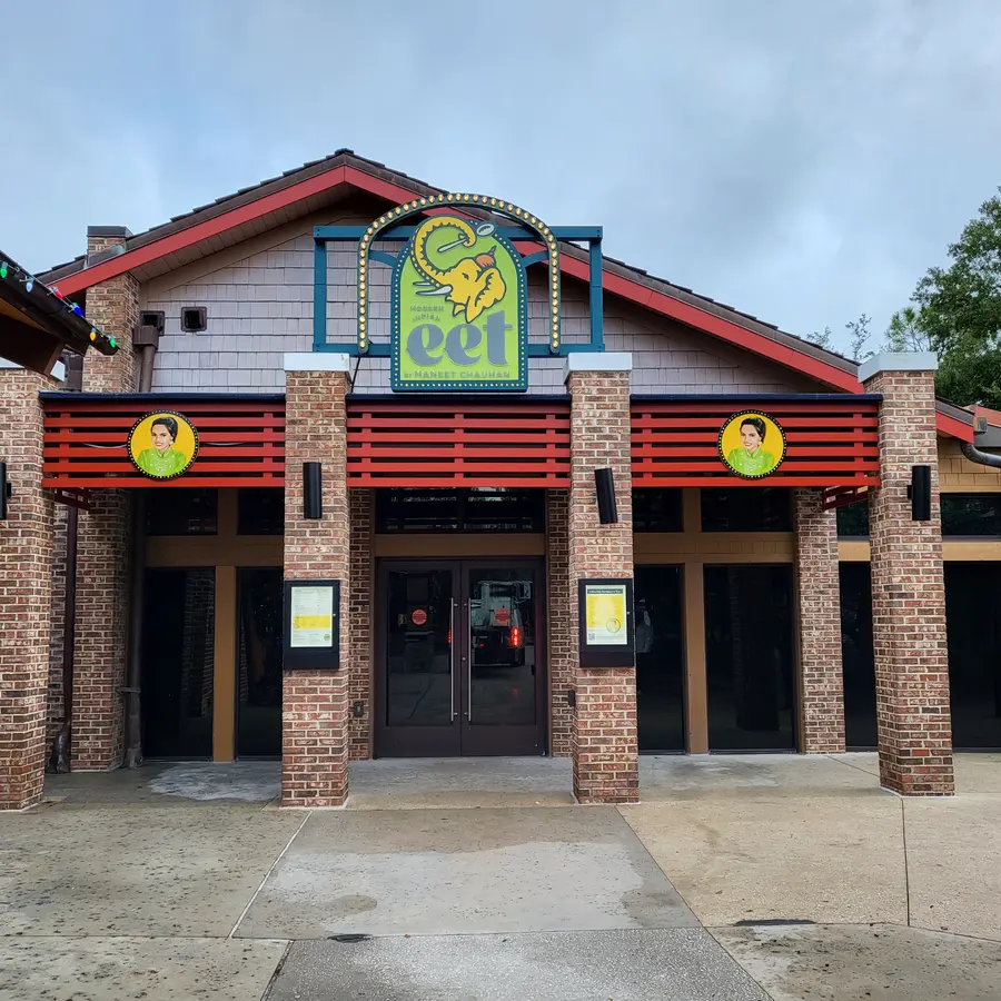 Eet restaurant facade with custom illuminated marquee logo sign and round medallion signs