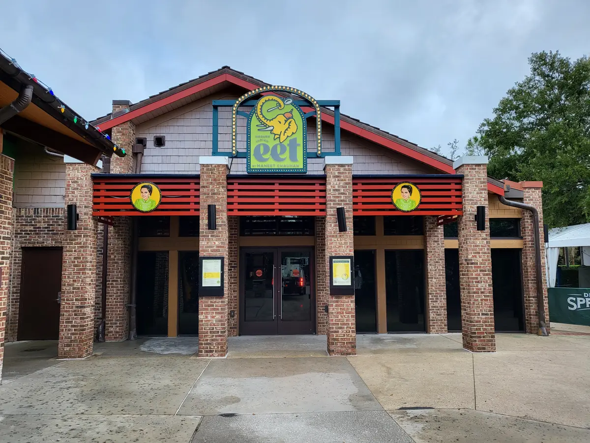Eet restaurant facade with custom illuminated marquee logo sign and round medallion signs