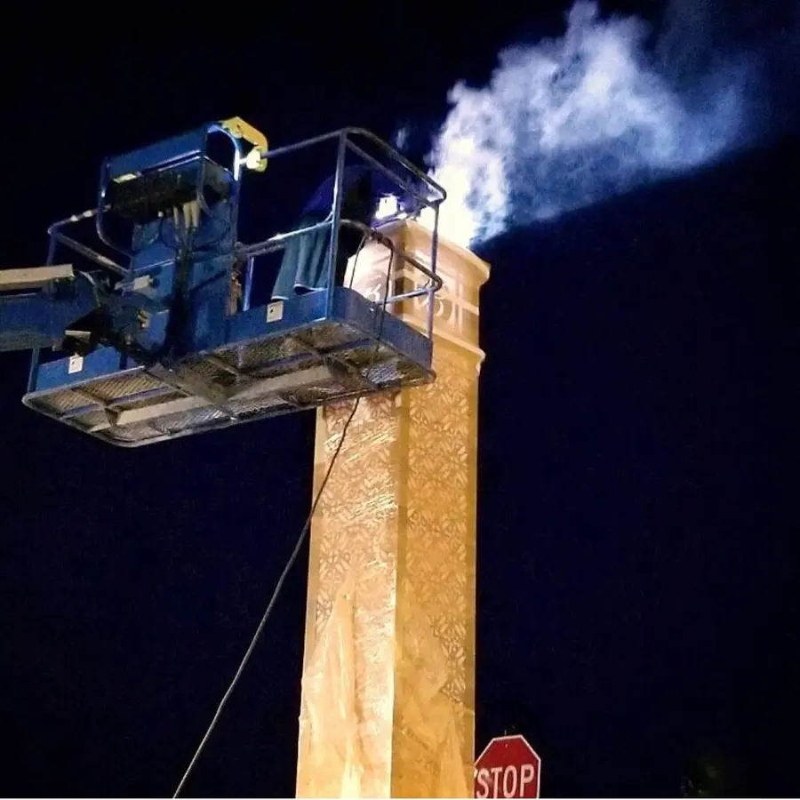 Night sign installation from a bucket truck, with welding sparks