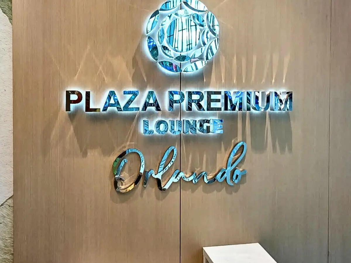 Plaza Premium Lounge illuminated logo inside the airport lounge