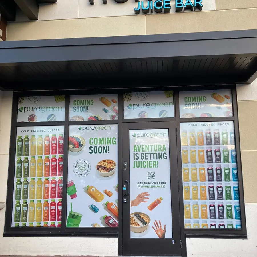 Pure Green coming soon window graphics on a juice bar storefront
